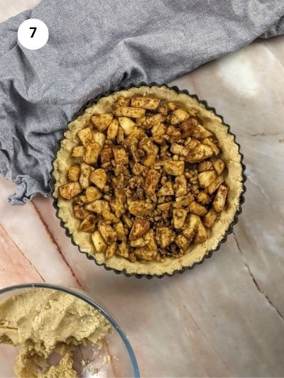 Adding the apple and walnuts filling on top of the dough.