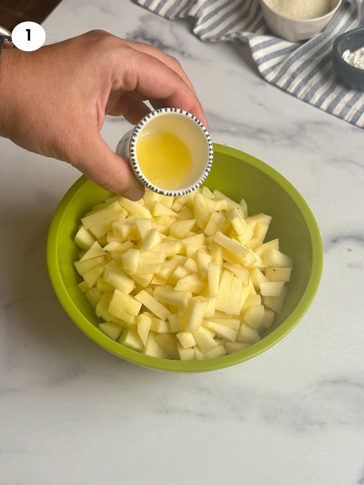 Adding lemon juice to chopped apples.