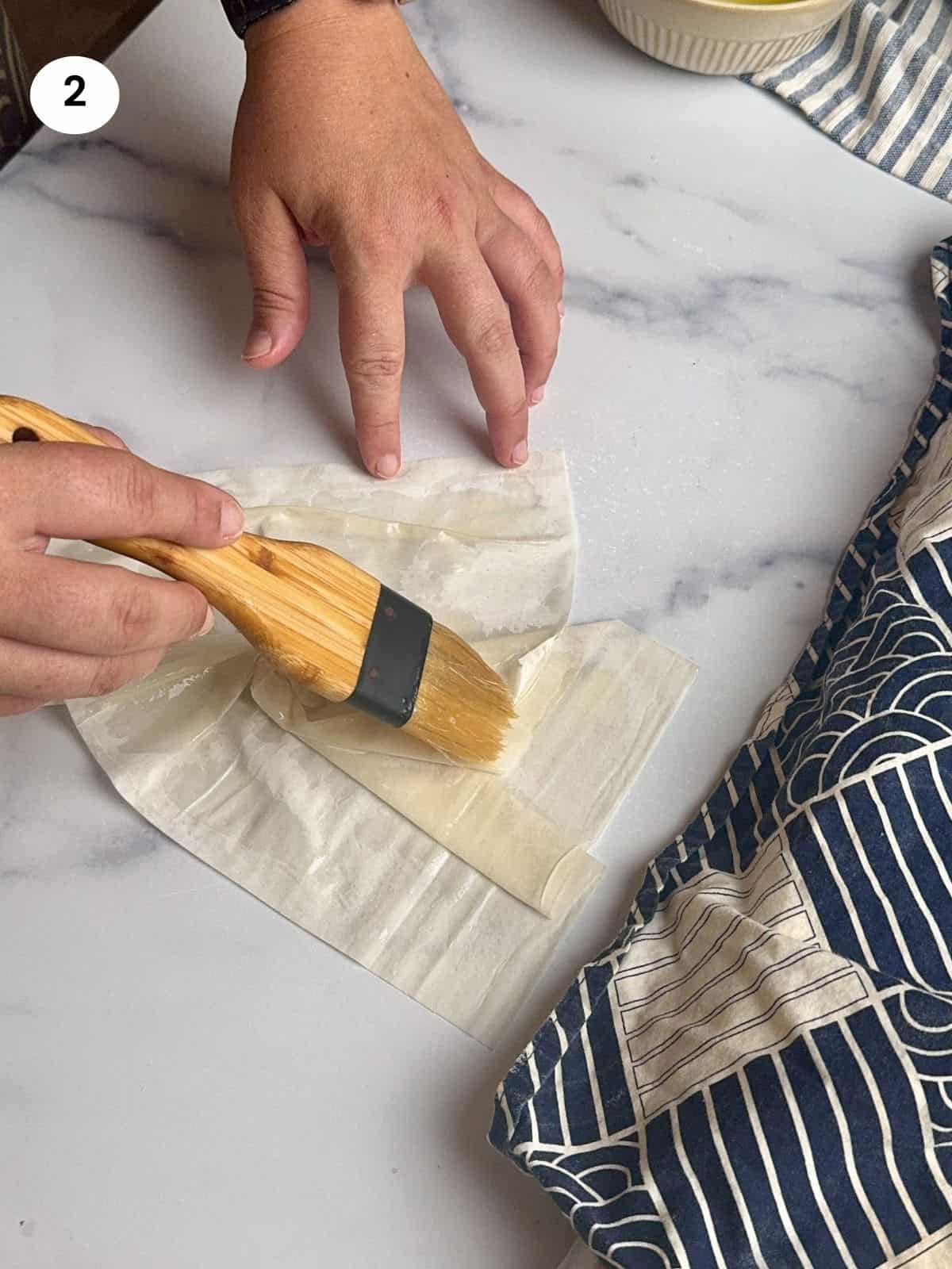 Brushing the twisted phyllo with butter.