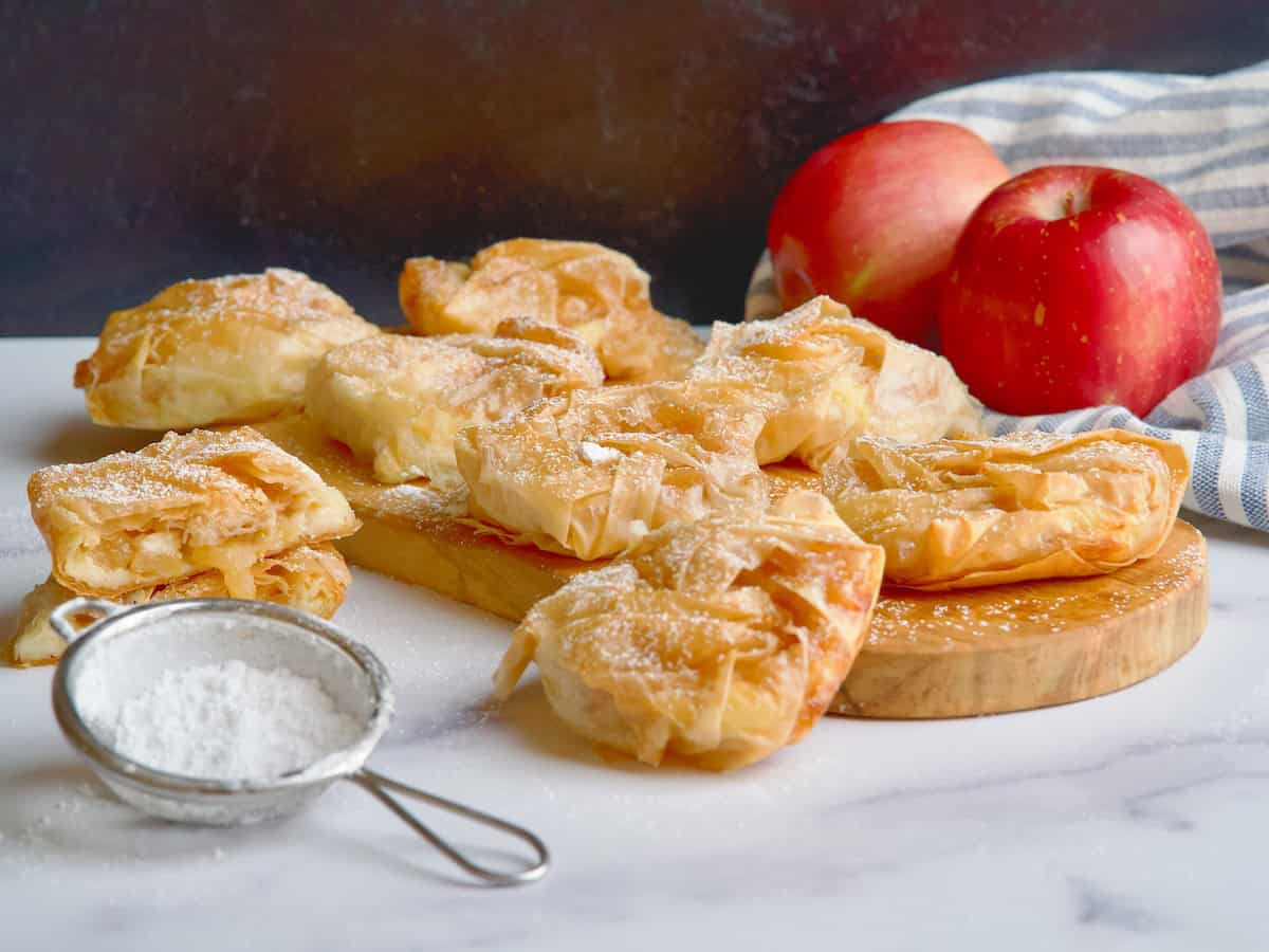 Apple and custard phyllo pastries on a wooden board Apple and custard phyllo pastries on a wooden board.