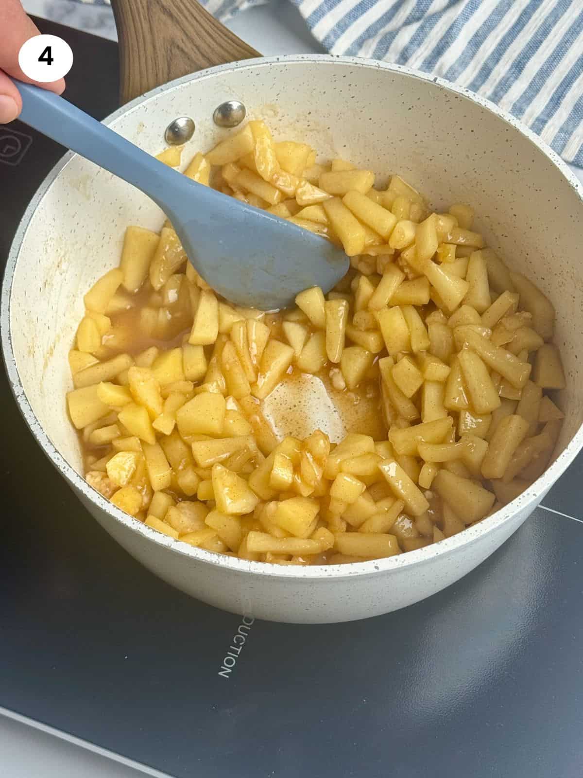 Showing thickened apple sauce with a spatula.