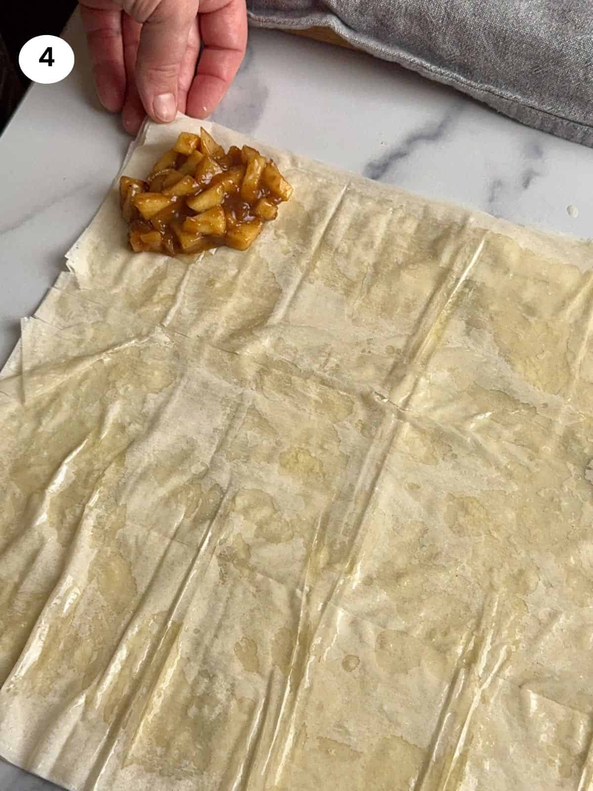 Adding the apple filling to the bottom of the first strip.