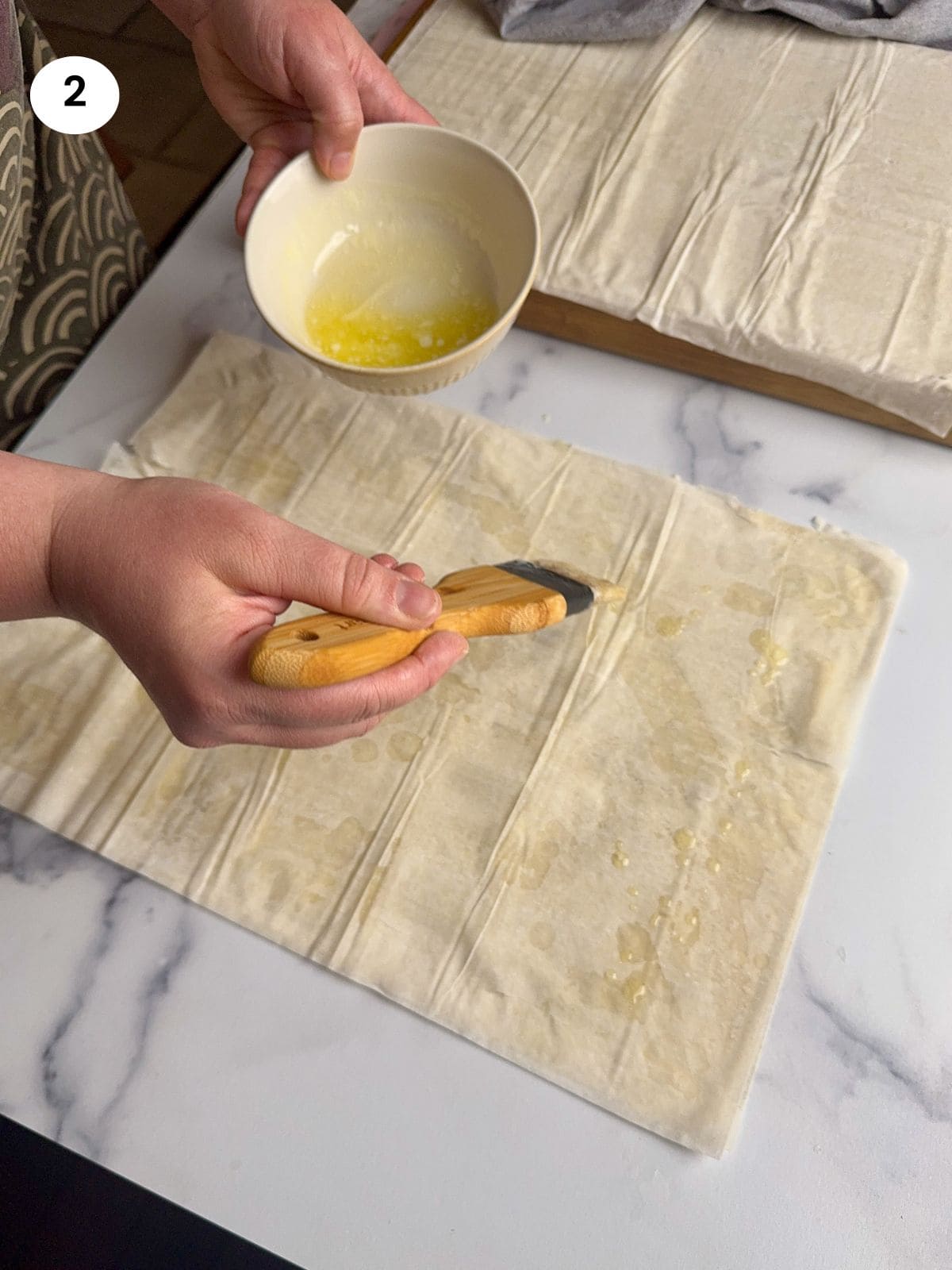 Third layer of phyllo and drizzling with butter.