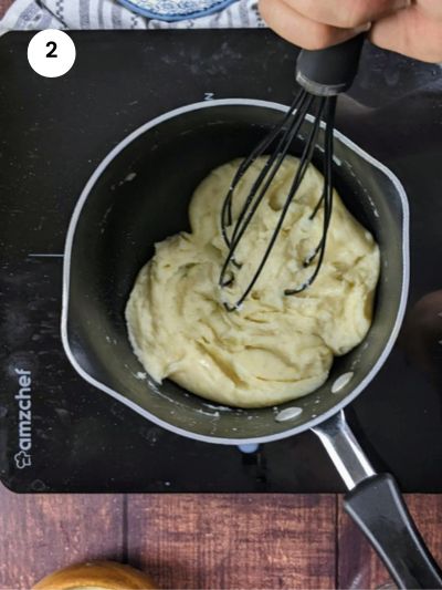 Adding the milk little by little to the flour mixture.