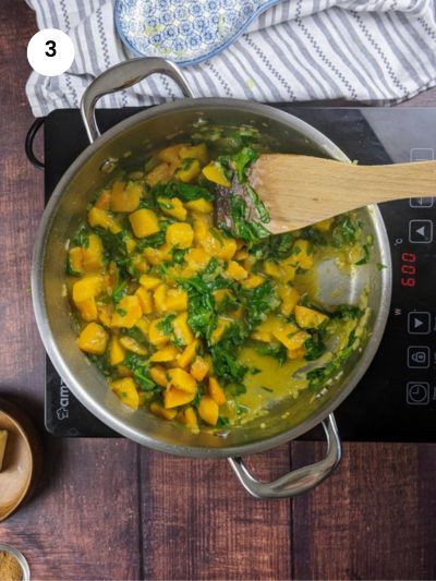 Adding the chopped spinach to the pot.