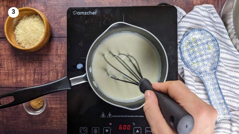 Creamy béchamel sauce after adding all the milk and whisking.