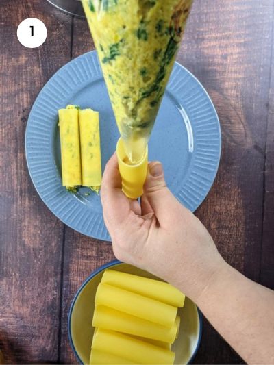 Piping the squash and ricotta filling in a cannelloni.