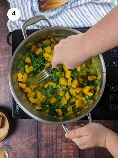 Mashing the squash with a fork.