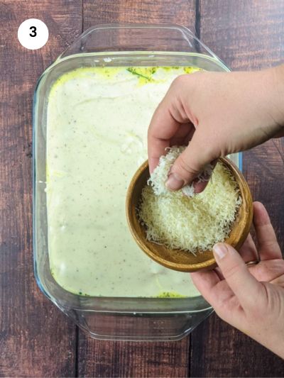 Topping up with parmesan cheese on top of béchamel.