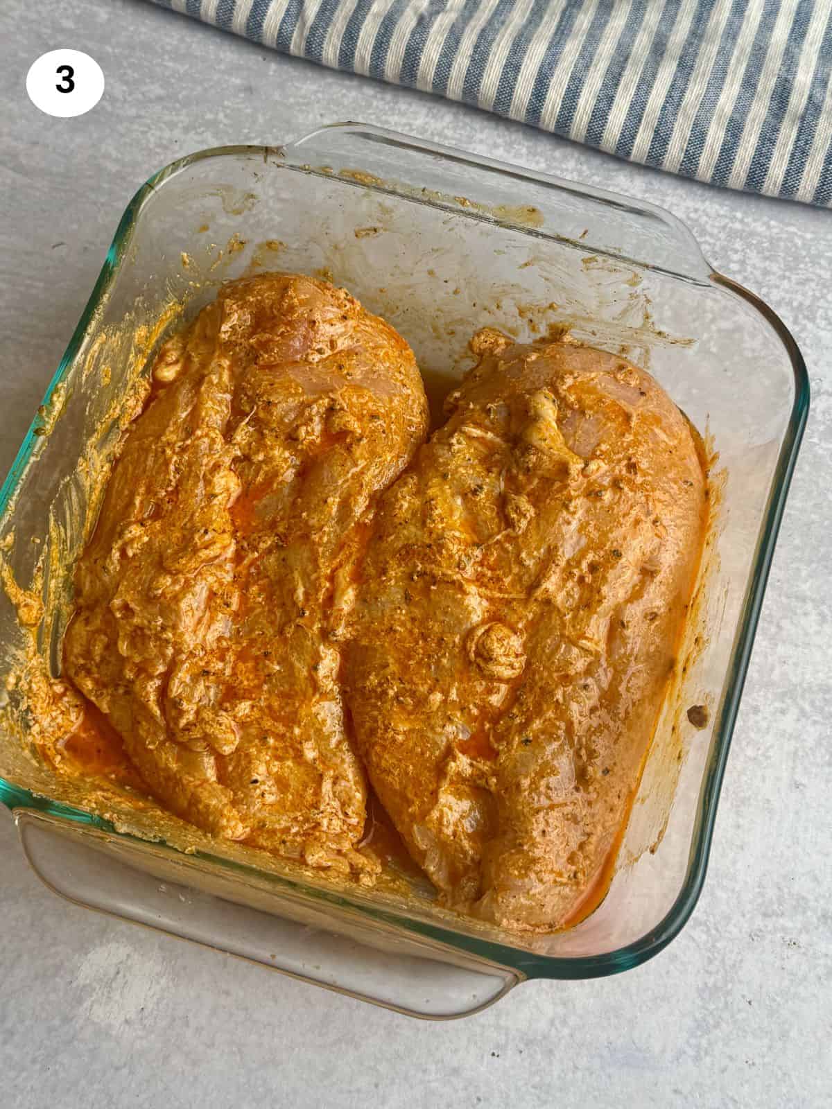 Rubbing the chicken breasts with the seasoning.