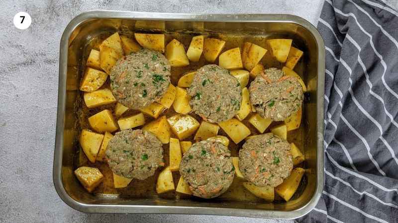Placing the meatballs on top of the potatoes