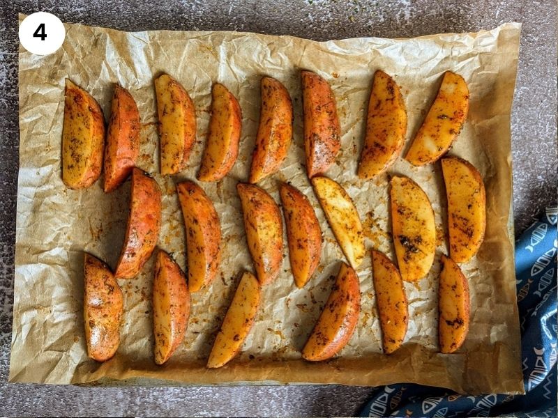 Coated potato wedges on the tray ready to be baked.