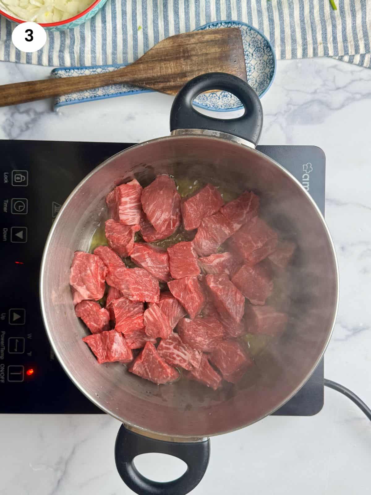 Browning the beef chunks.