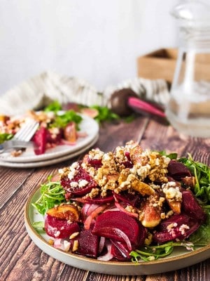 Beet and fig salad served on plate with a jug of water at the back.