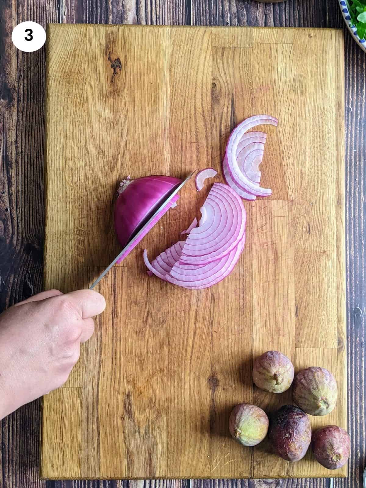 Κόβωντας το κρεμμύδι σε φέτες.