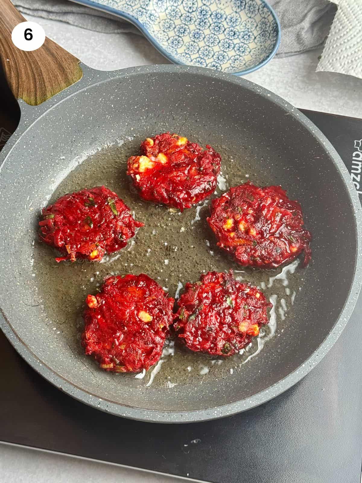 Beet fritters flipped to cook on the other side.