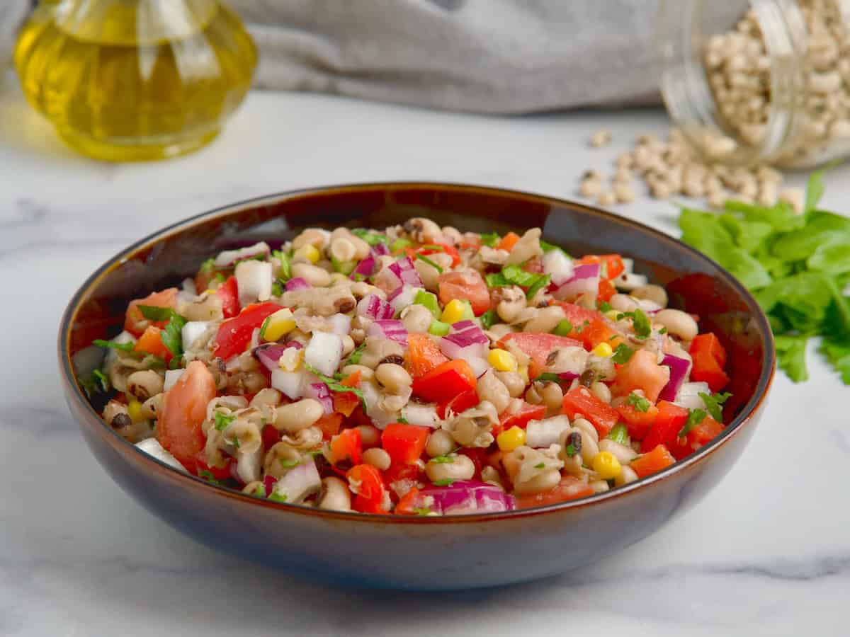 Black-eyed peas and corn salad served in a black bowl Black-eyed peas and corn salad served in a black bowl.