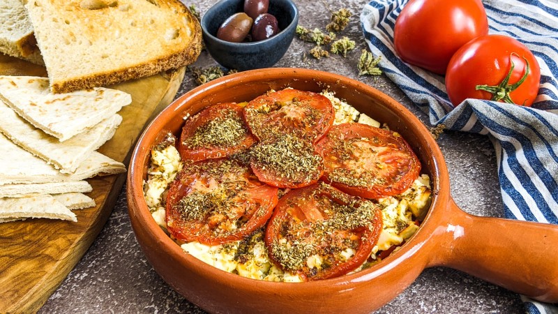 Baked feta cheese with tomatoes when it comes out of the oven.