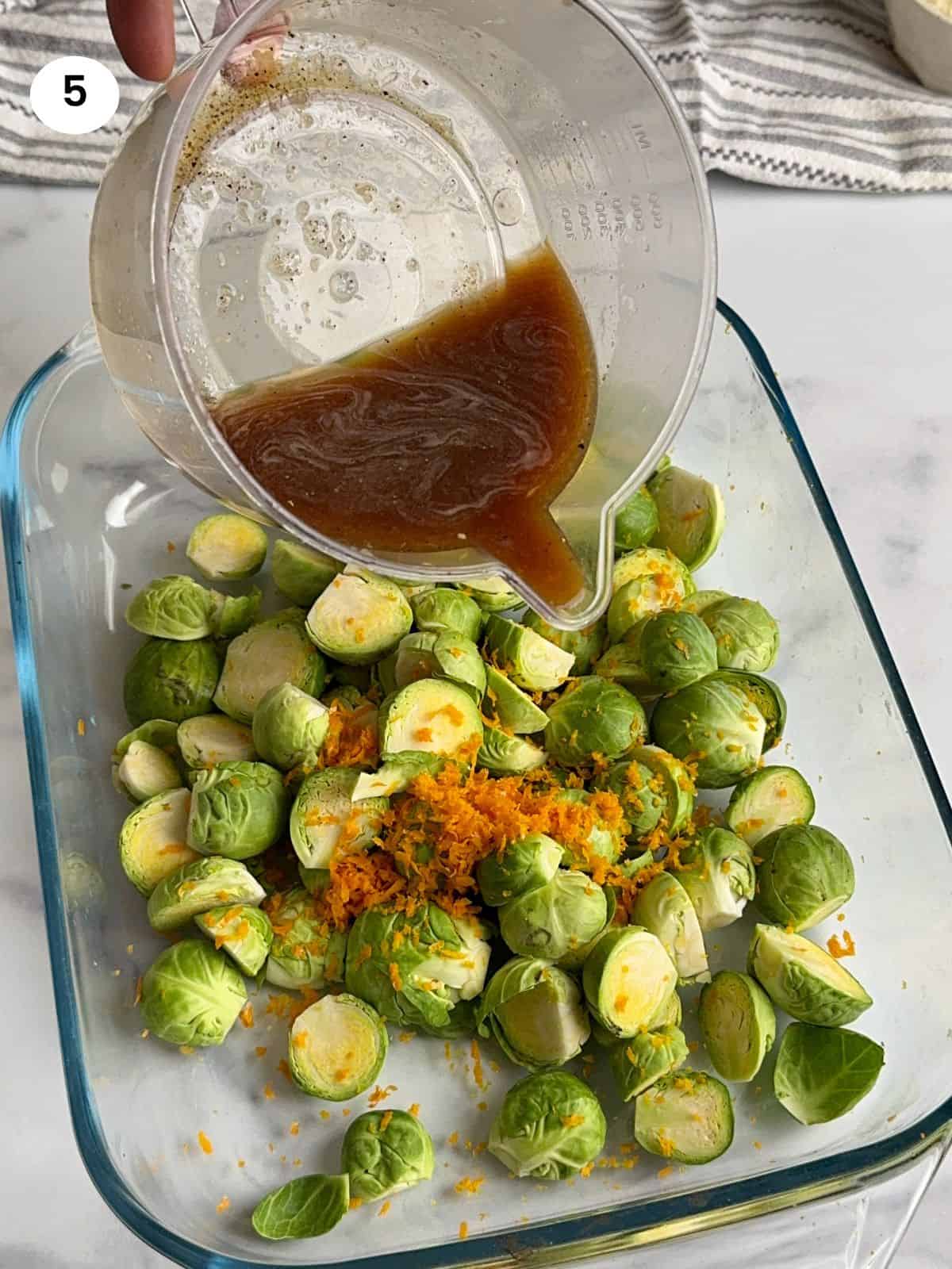 Adding the dressing for the roasted brussels sprouts.