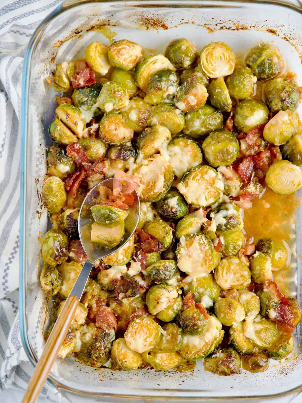 Roasted brussels sprouts served on blue plate next to orange and raw sprouts