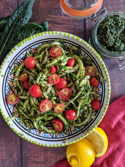 Zucchini noodles served with cavolo nero pesto and cherry tomatoes on top
