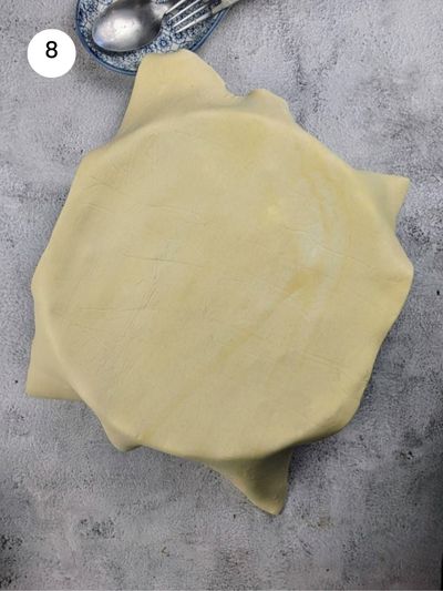 Placing the puff pastry sheet on top of the filling.