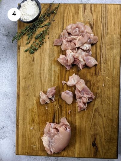 Cutting the boneless chicken into smaller chunks.