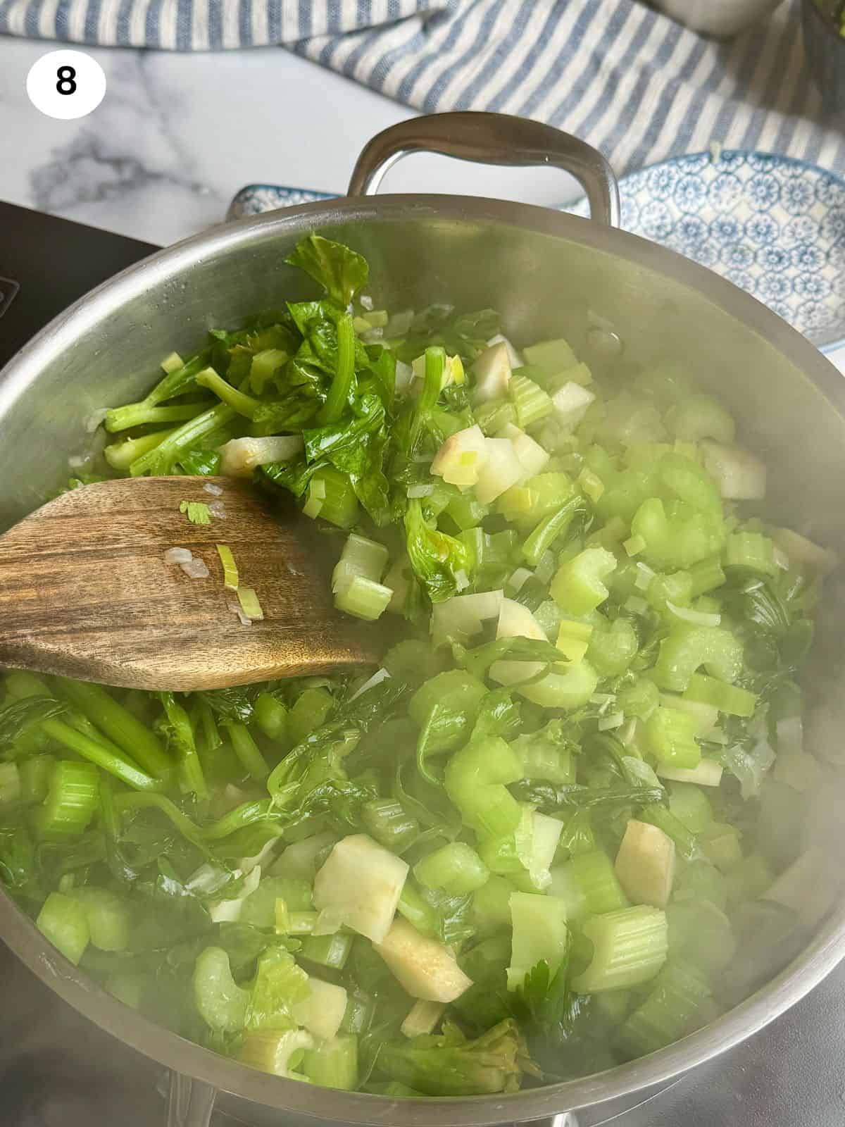 Stirring the celery until it reduces size.