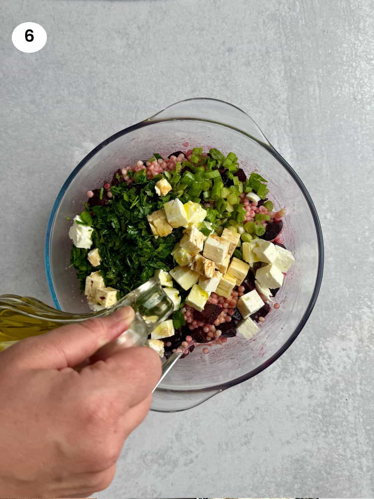 Pouring oil into the salad bowl.