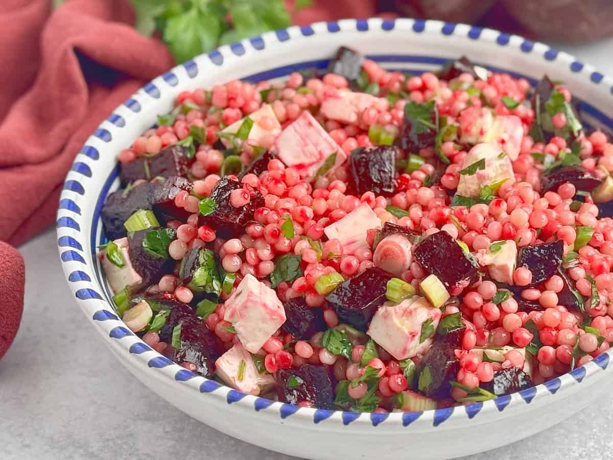 Roasted beets and couscous salad served in a blue plate.