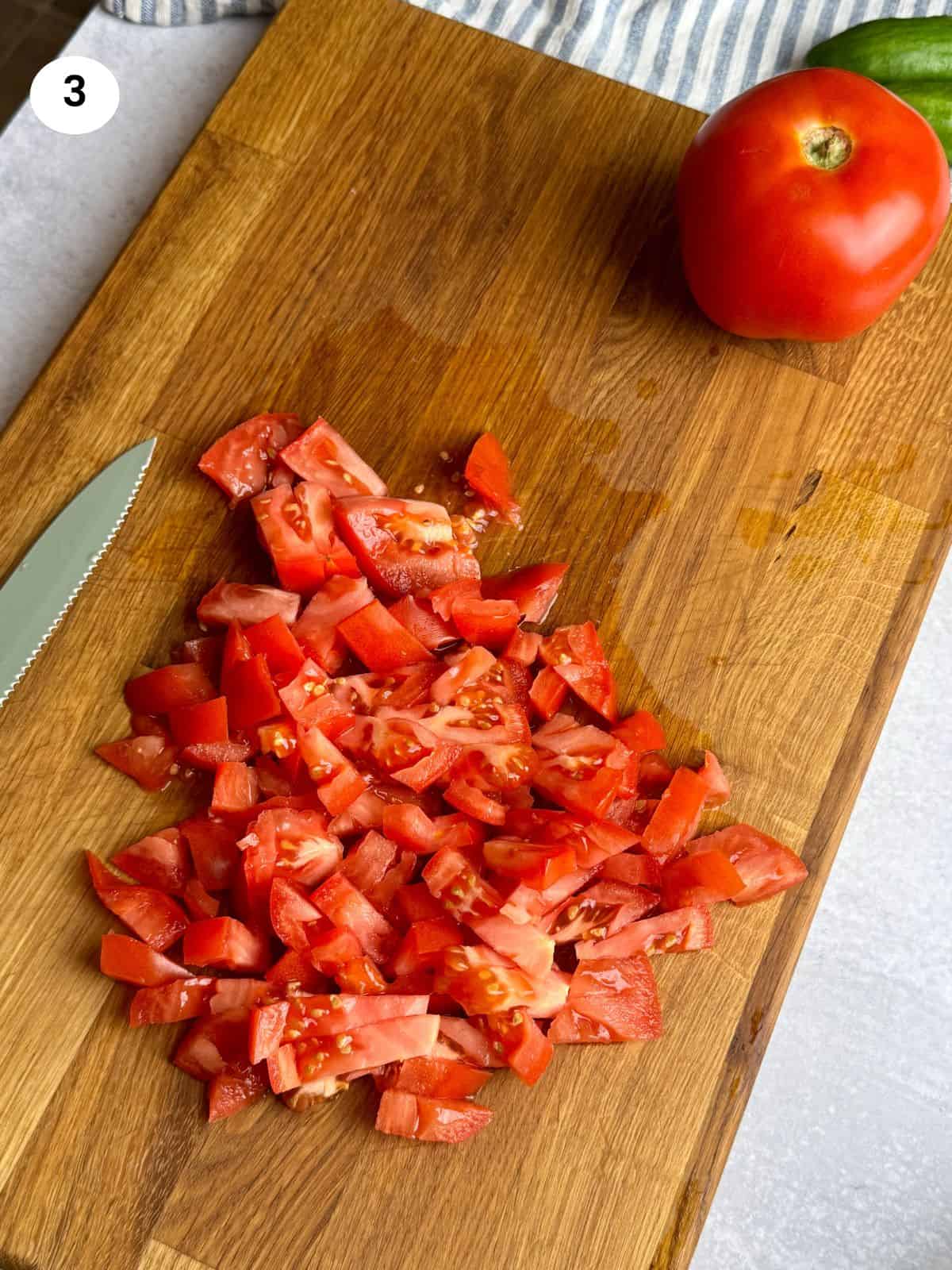 Chopped beef tomatoes on wooden board.