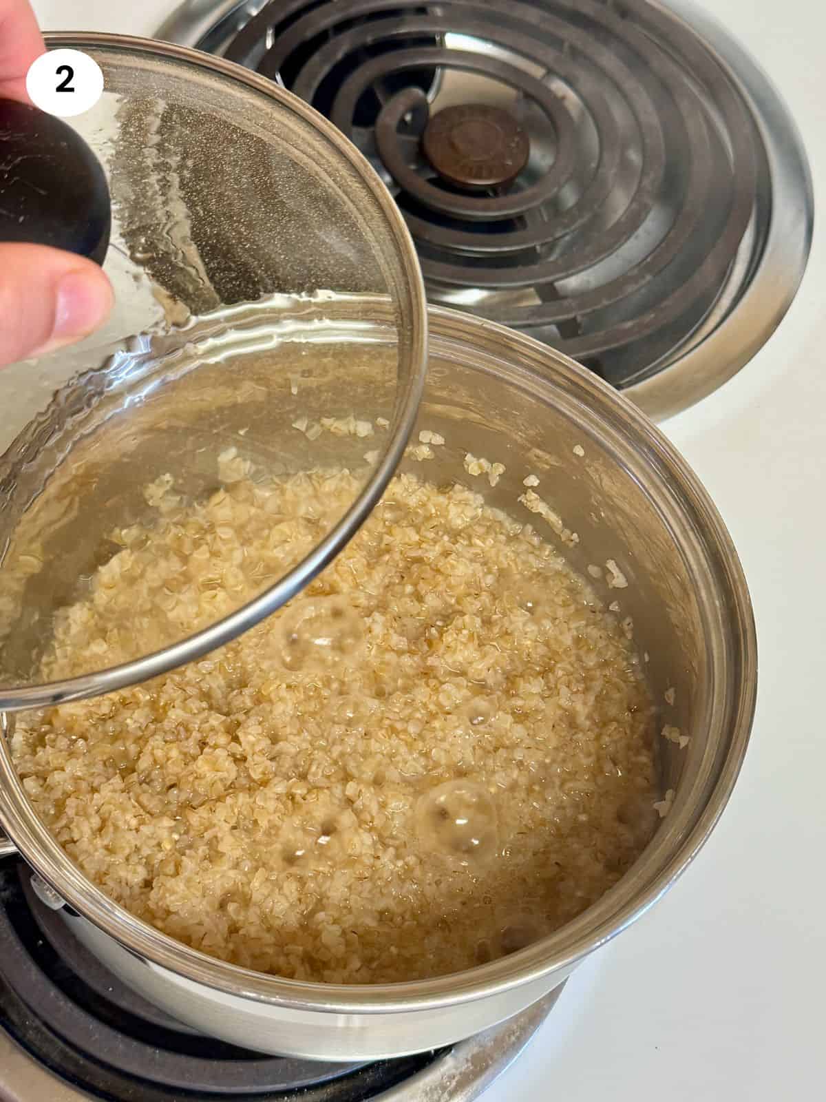 Cooked bulgur wheat in a pot and covering with a lid.