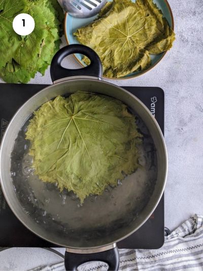 Blanching the grape leaves in boiling water.