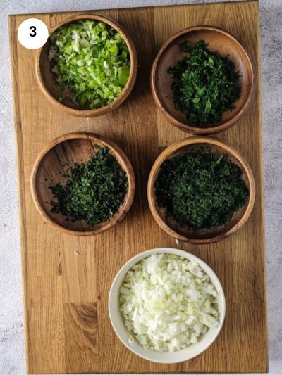 Chopped ingredients for dolmadakia in wooden bowls.