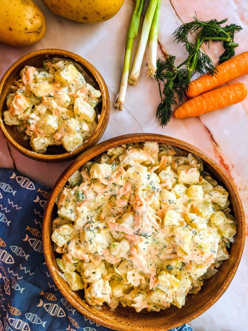 Creamy potato salad served in wooden bowl