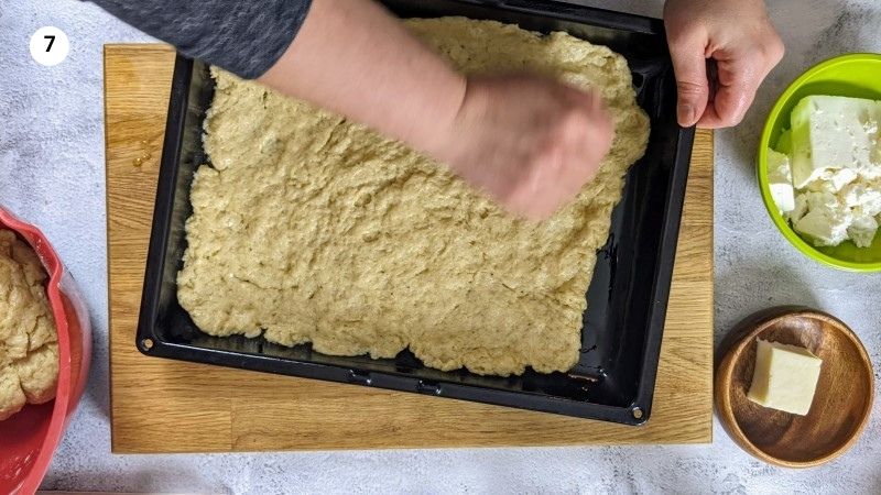 Adding the bottom layer for the feta bread Adding the bottom layer for the feta bread.