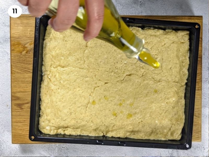 Drizzling with oil the top of the feta bread before putting it in the oven Drizzling with oil the top of the feta bread before putting it in the oven.