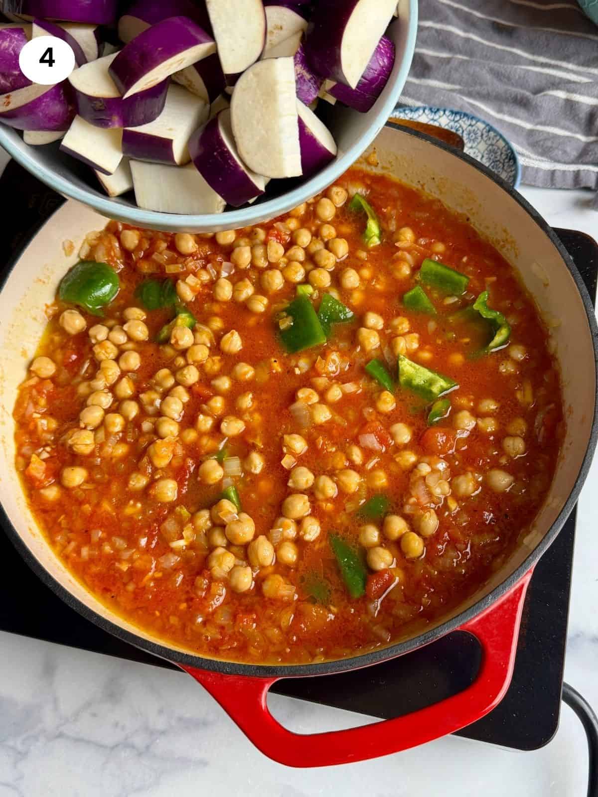 Adding the eggplant cubes to the pan.