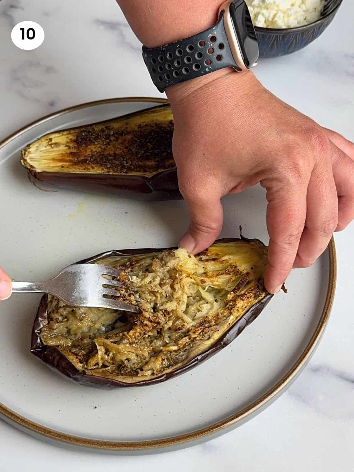 Shredding the eggplant flesh with a fork.
