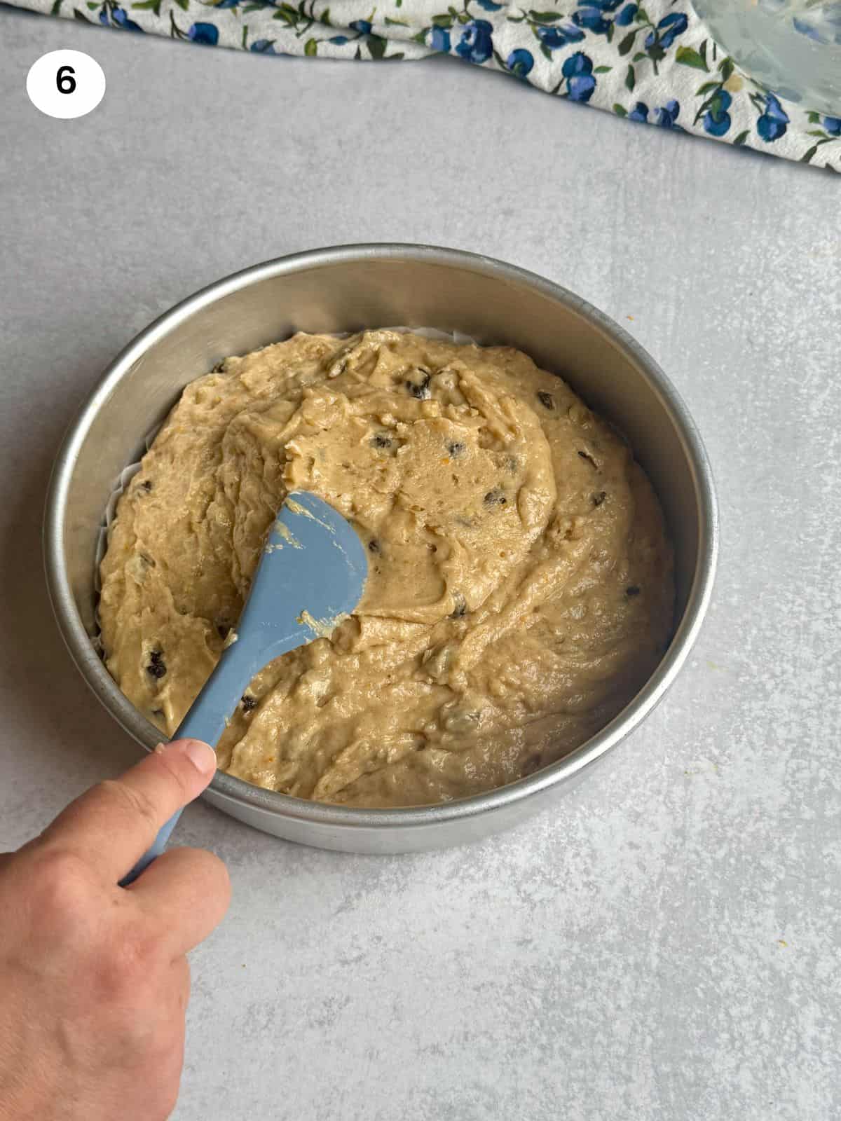 Spreading the batter inside the cake pan.