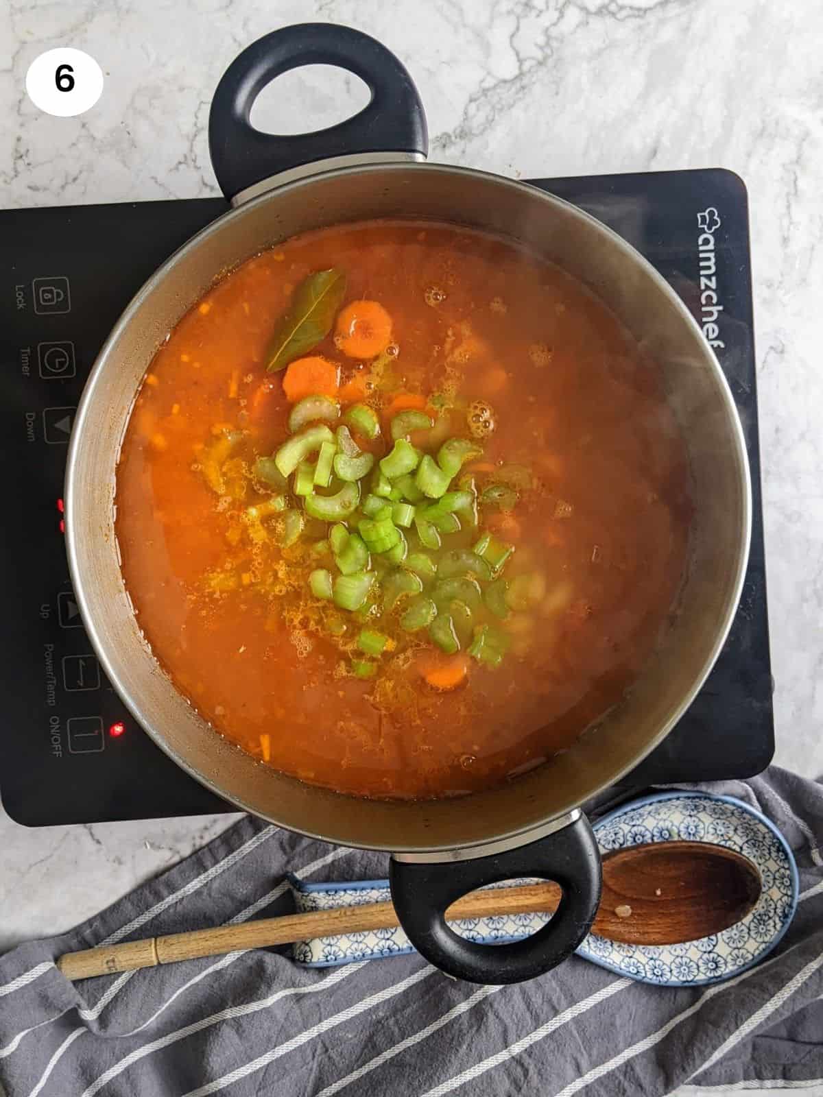 Adding carrots and celery to the pot.