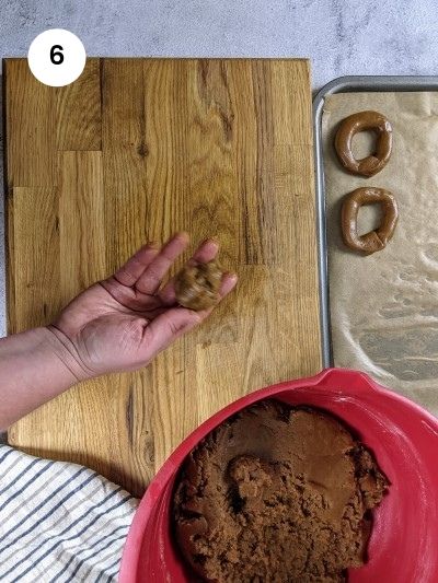 Taking a small piece of dough to start shaping the cookie.