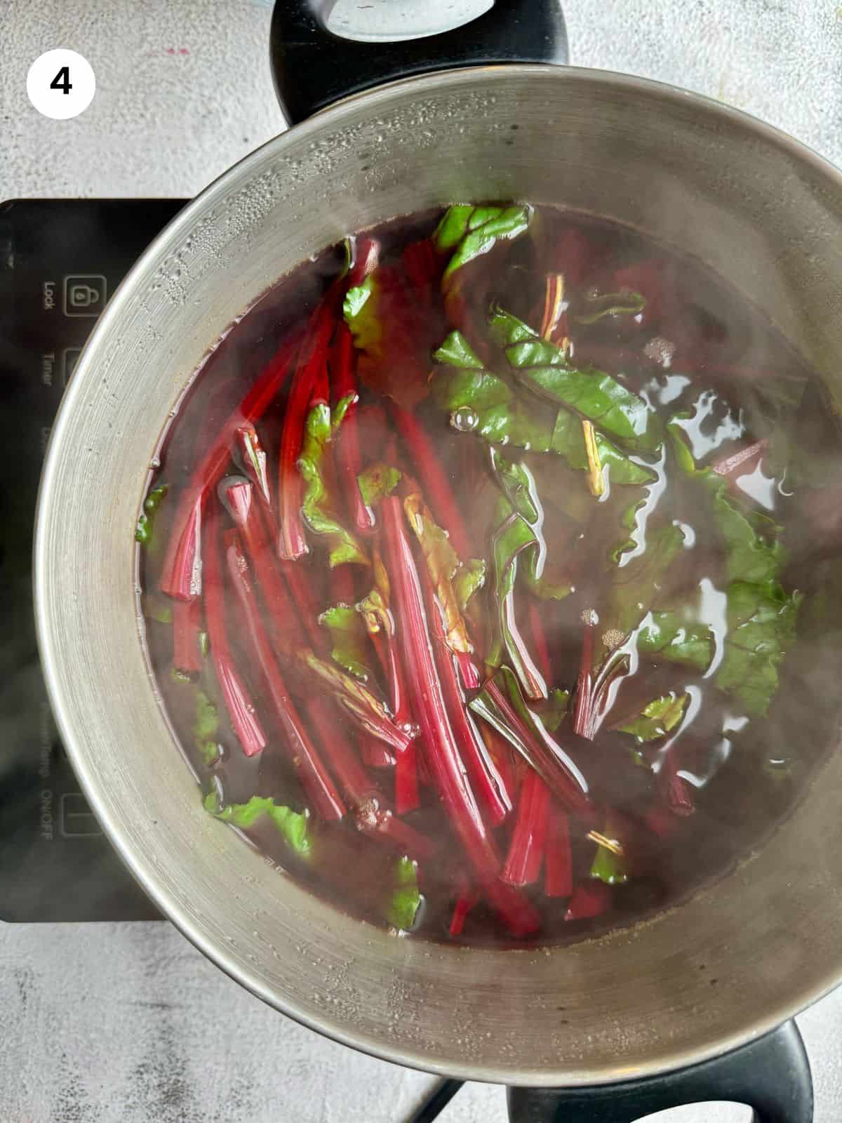 Boiling the beets and leaves until fork tender.