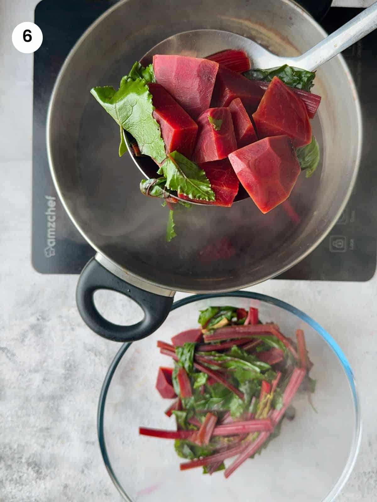 Draining beets from water with slotted spoon.