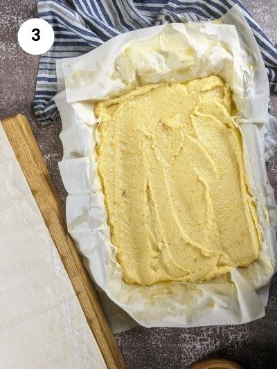 Adding the custard to the tray for bougatsa.