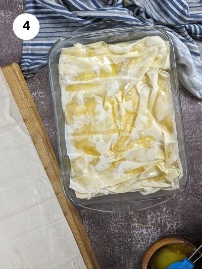 Adding the top phyllo pastries to cover the custard.