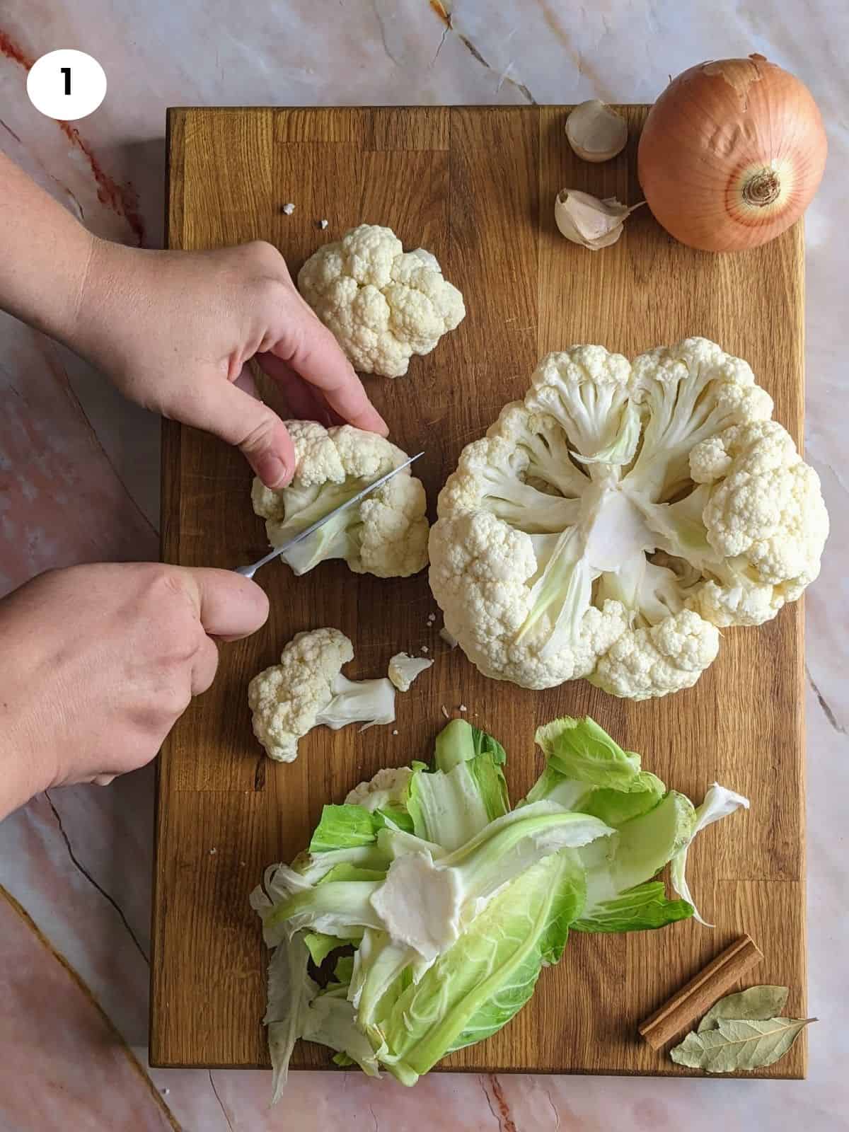 Cutting cauliflower head into florets.