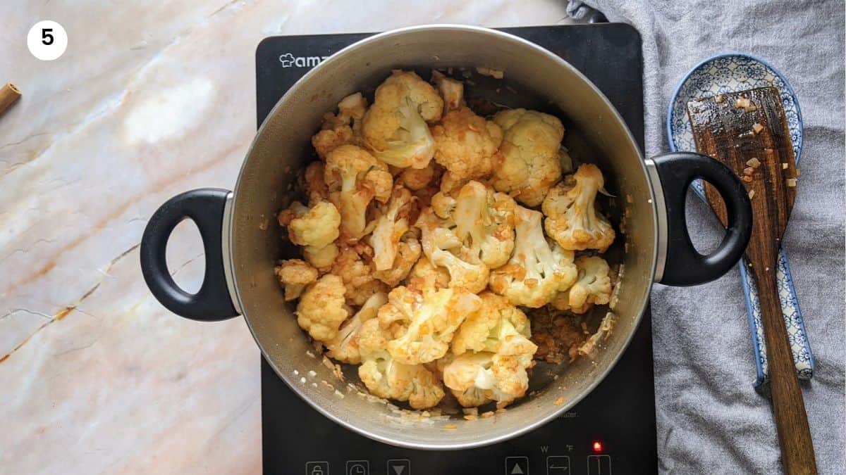 Cauliflower, tomatoes and spices in the pot Cauliflower, tomatoes and spices in the pot.