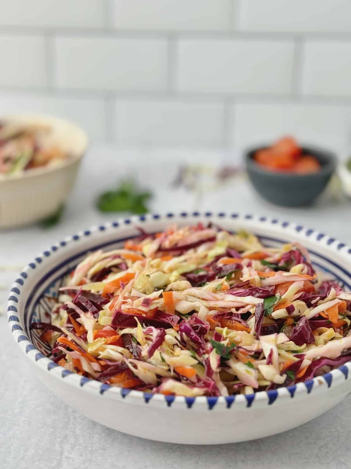 Greek cabbage salad served in blue patterned bowl.