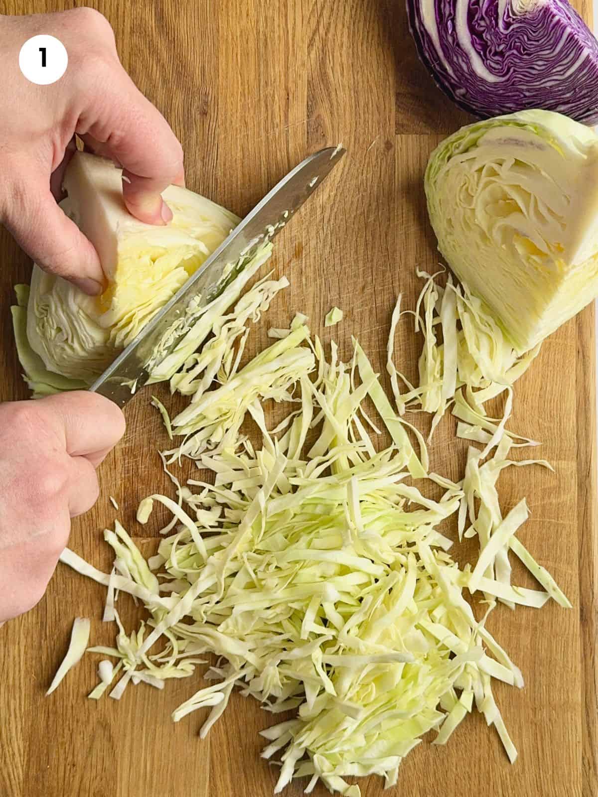 Shredding the green cabbage into thin slices.